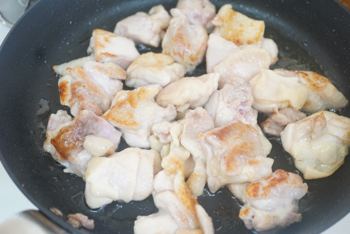 bite size piece chiken thighs being grilled in pan