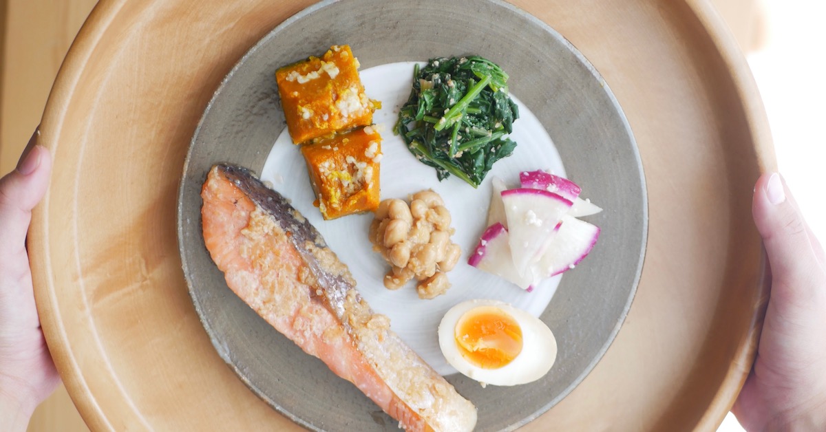 Salmon, kabocha, spinach, beans, radish and boiled egg on a plate