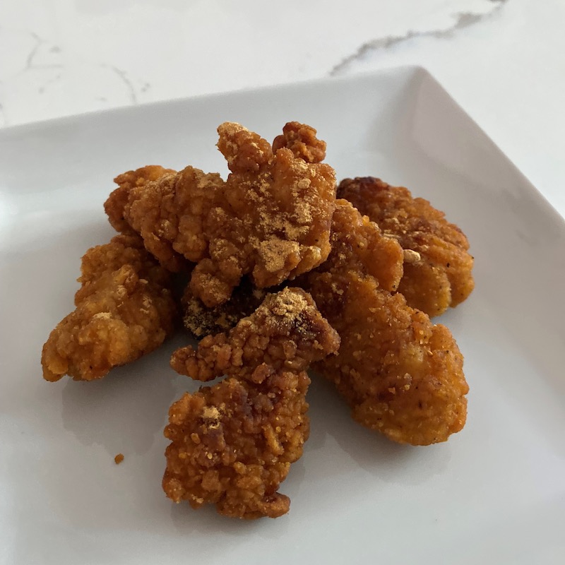 Fried chicken with soy sauce powder on a white plate