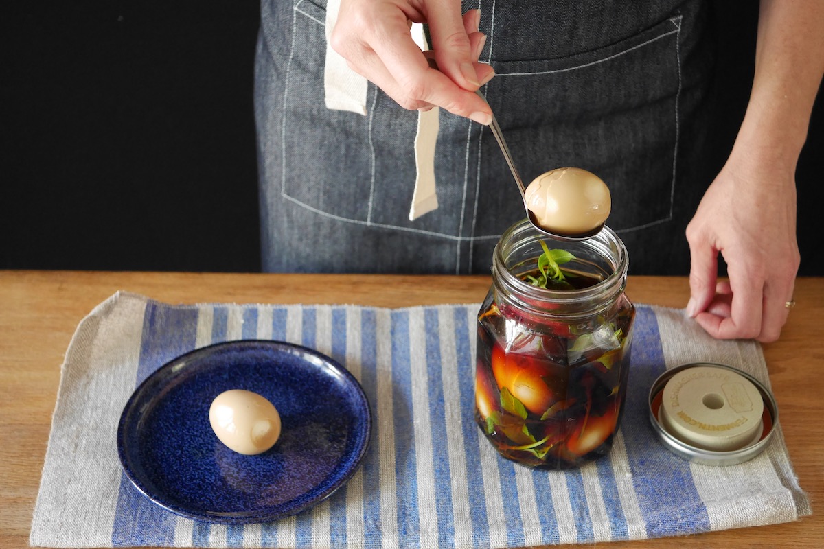 Shoyuzuke egg on a blue plate and shoyuzuke eggs in a jar