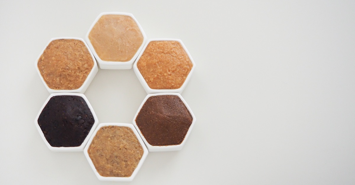 Six different kinds of miso each in a white container arranged in a hexagon shape